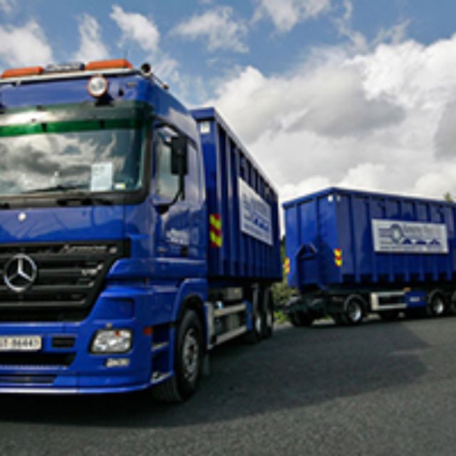 Flere av Norscrap West AS sine lastebiler med containere festet til seg